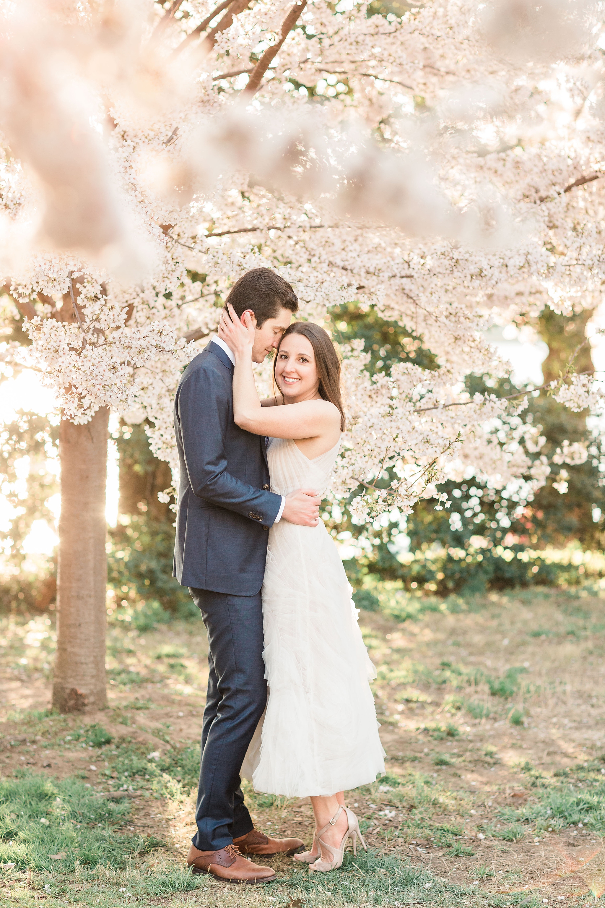 A stylish cherry blossom engagement session at the Tidal Basin in Washington, DC during peak bloom.