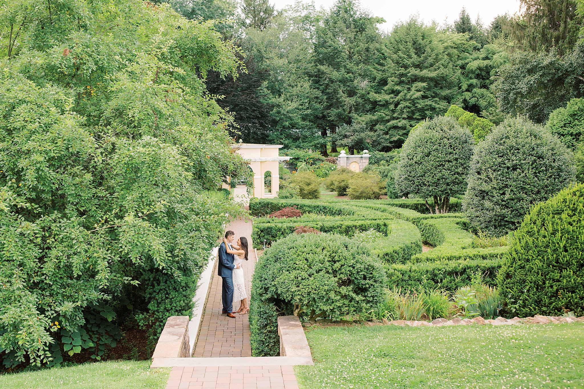 An elegant garden engagement session at Airlie Center in Warrenton, VA featuring a goldendoodle puppy. 