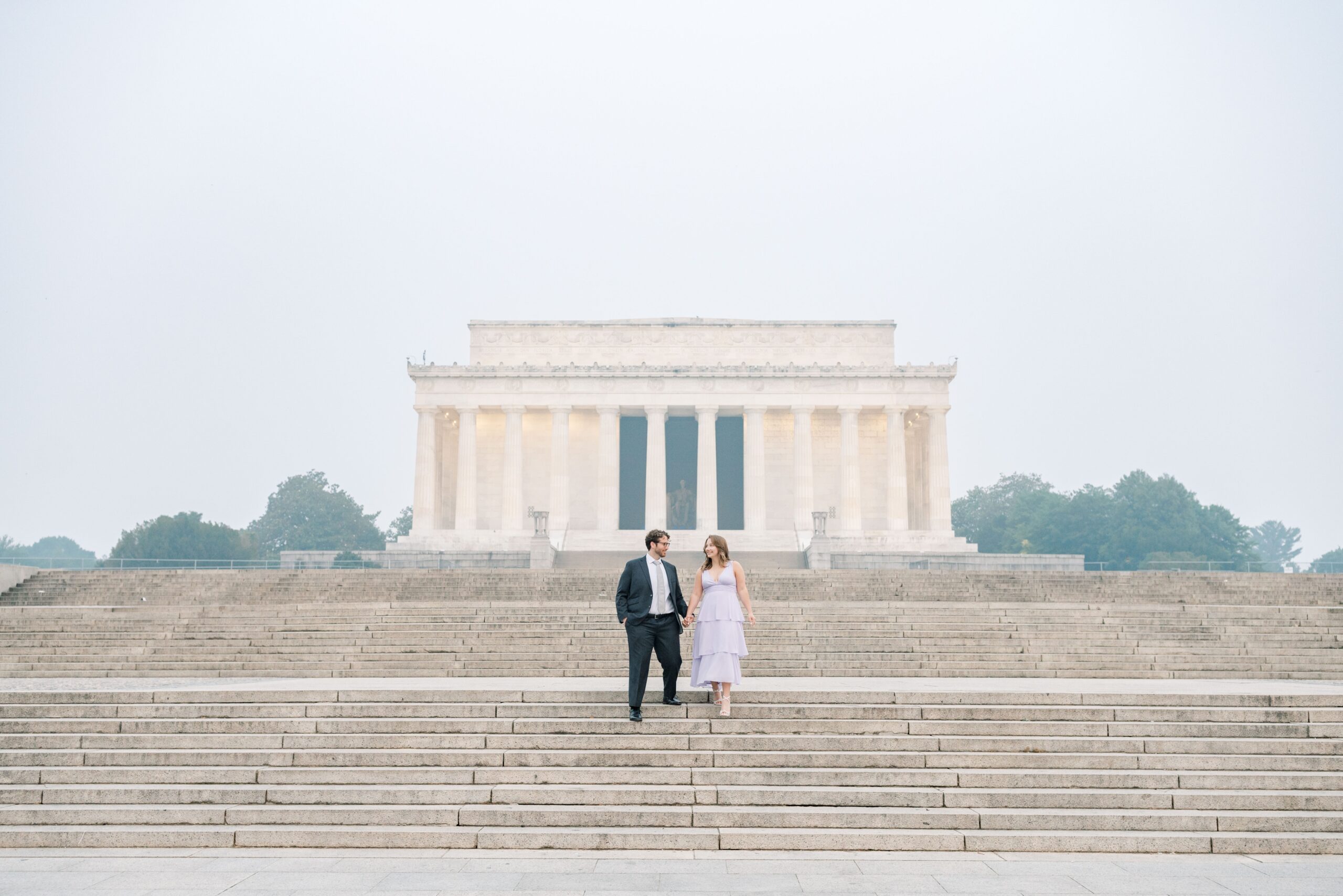 Hazy Washington Monument and Lincoln Memorial engagement photos in Washington, DC.