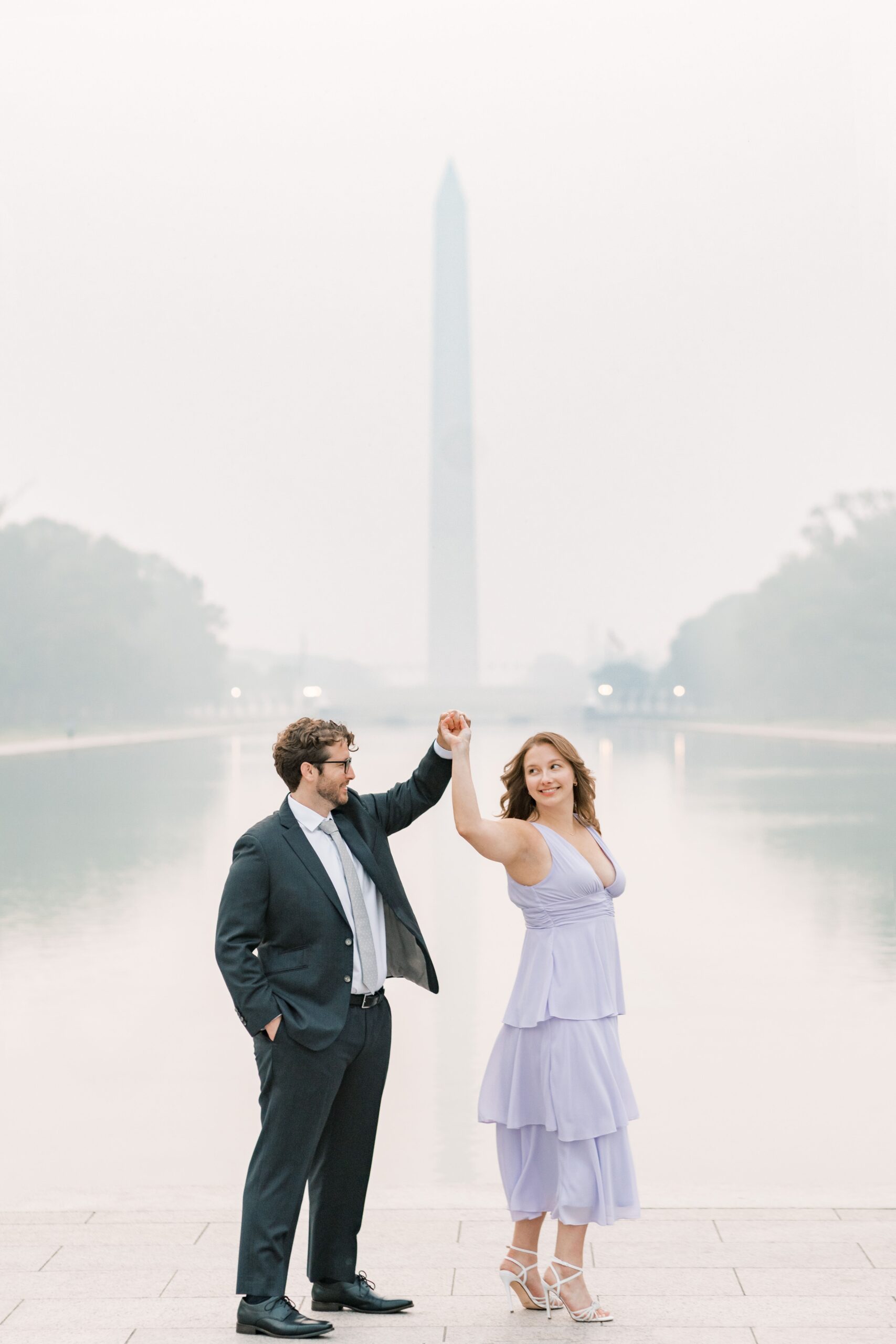 Hazy Washington Monument and Reflecting Pool engagement photos in Washington, DC.