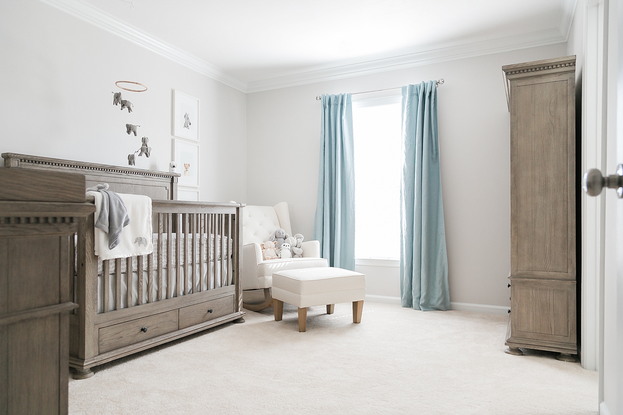 This chic grey and blue nursery for a baby boy features Restoration Hardware furniture, an upgraded closet, and elephant decor.