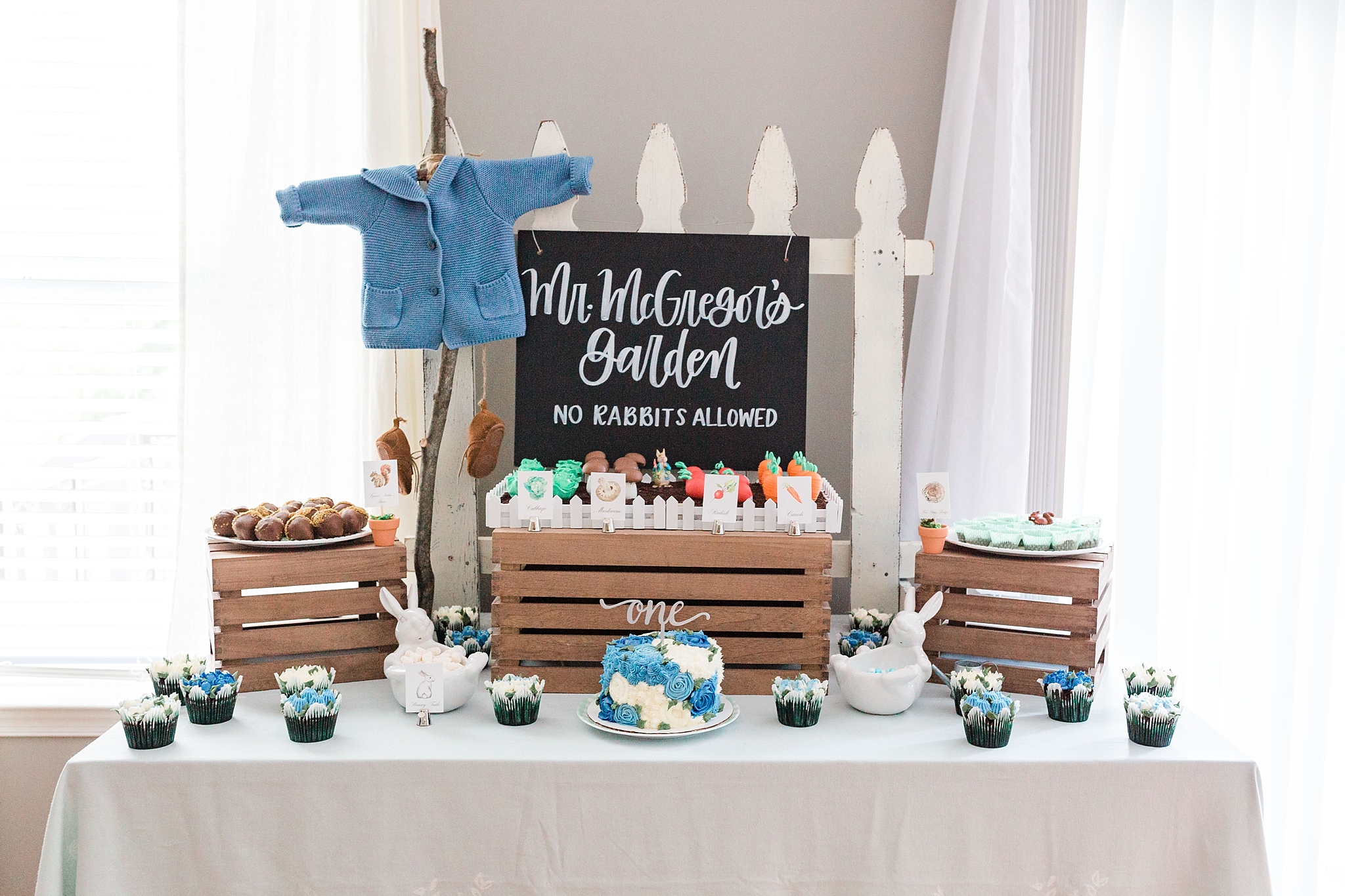 A stunning Peter Rabbit first birthday party complete with a cake pop vegetable garden, dessert station, mimosa bar, and custom cookies!
