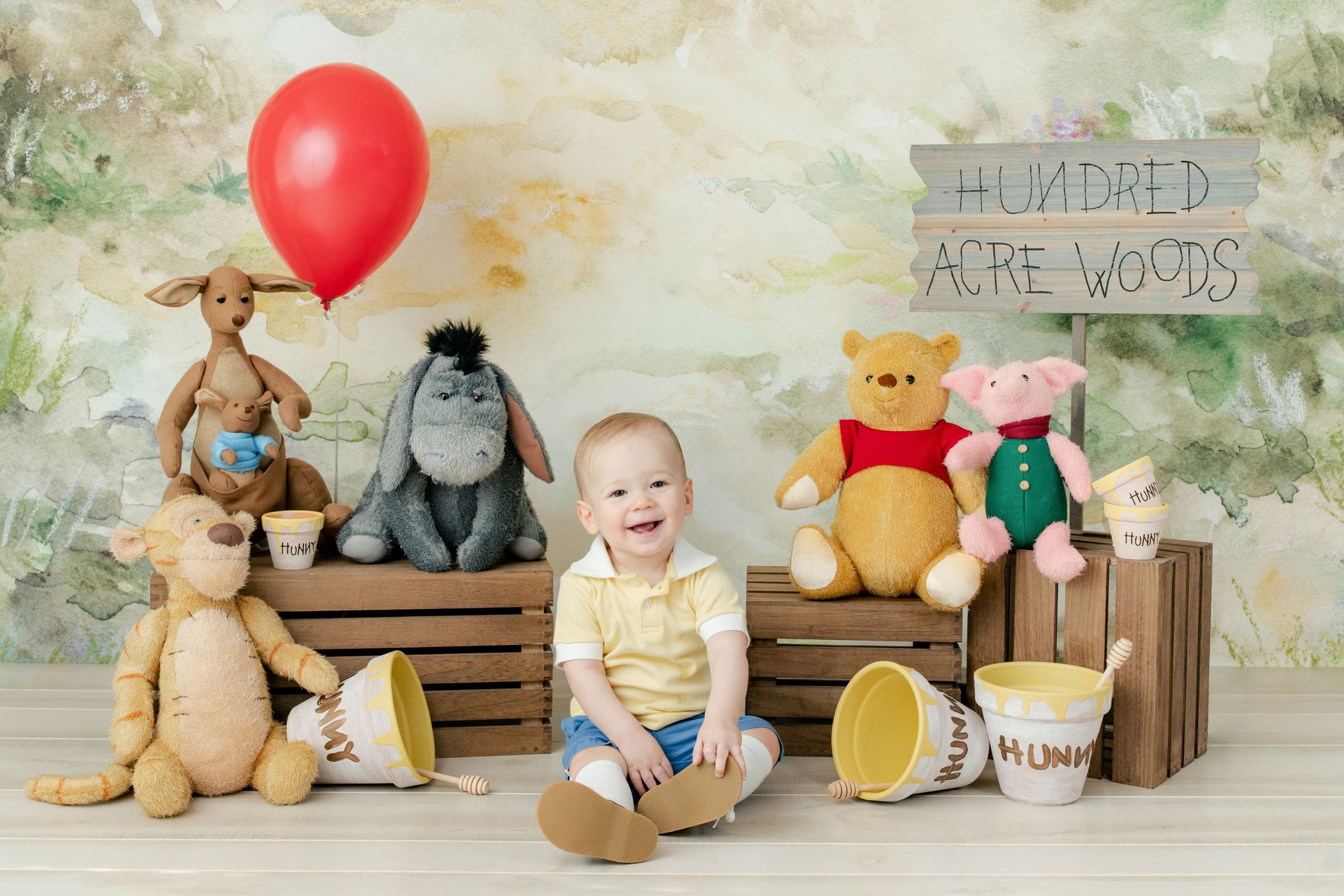 A Winnie the Pooh first birthday part complete with a hunny pot cake, Mr. Sanders' Fishing Hole, Hundred Acre Wood, and more!